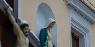 Apakah Maria “Co-Redemptrix”? Dogma Berikutnya? Gelar yang Saleh? Bid’ah atau Penistaan? a statue of a person holding a cross in front of a building