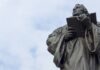 Membongkar Kesesatan Martin Luther Menambahkan “Sola” dalam Kita Suci man holding book statue under white clouds during daytime