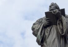 Membongkar Kesesatan Martin Luther Menambahkan “Sola” dalam Kita Suci man holding book statue under white clouds during daytime